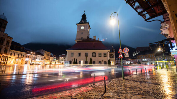 Long exposure shot of The Council Square in Brasov at night, Romania. Old city centre, classic buildings, nightlights, light trails