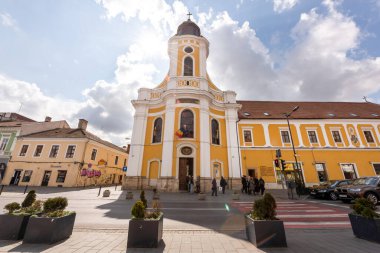 CLUJ, ROMANIA - Nisan 2022: Şehir merkezinin sokak manzarası. Kilisesi, insanları, arabaları ve eski binaları olan bir sokak.