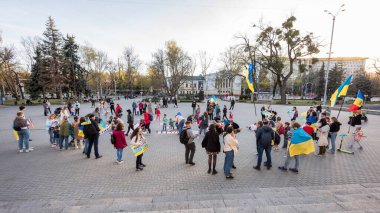 CHISINAU, MOLDOVA - Nisan 2022: Rusya 'nın Ukrayna' nın merkezdeki işgaline karşı protestolar. Ukrayna bayrakları ve posterleri olan bir sürü insan ve çocuk. Yere yazıt.