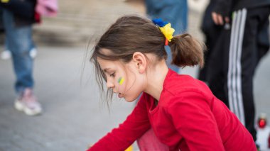 CHISINAU, MOLDOVA - Nisan 2022: Rusya 'nın Ukrayna' nın merkezdeki işgaline karşı protestolar. Ukrayna bayrağı taşıyan çocuk sığınak lambaları yakıyor