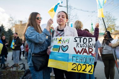 CHISINAU, MOLDOVA - Nisan 2022: Rusya 'nın Ukrayna' nın merkezdeki işgaline karşı protestolar. Yanağında Ukrayna bayrağı olan bir kadın resmedilmiş.