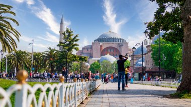 İSTANBUL, TURKEY- Nisan 2022: Ayasofya 'nın fotoğraflarını çeken bir turiste gün ışığı perspektifi