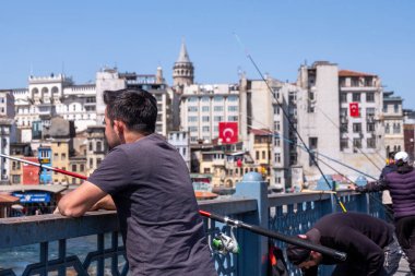 İnsanlar dinleniyor ve Türkiye 'nin tekneleri ve kırmızı bayraklarıyla dolu Bosfor Chanel manzarasının keyfini çıkarıyorlar.