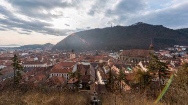 Romanya 'nın eski Brasov merkez manzarası. Siyah Kilise ve Konsey Meydanı, eski yerleşim yerleri, tepeler, bulutlar