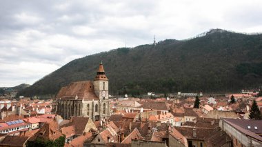Romanya 'nın eski Brasov merkez manzarası. Siyah Kilise, eski yerleşim yerleri, tepeler, bulutlar.