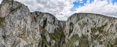 Romanya 'daki kayalık bir kanyonun panoramik hava aracı görüntüsü. İnce bitki örtüsü olan kayalık kayalıklar