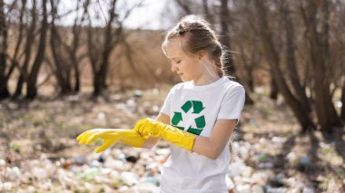 Kirli temizleme, geri dönüşüm tabelasında plastik çöp toplamak için lastik eldiven takan bir kız.