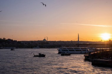 Türk denizinin olağanüstü sarı gün batımı, uçan martılar ve yüzen tekneler