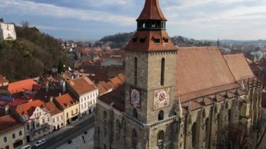 BRASOV, ROMANIA - APRIL, 2022: Romanya 'nın Brasov kentindeki merkez Konsey Meydanı' nın hava aracı görüntüsü. Siyah kilisesi, binaları, insanları olan eski şehir merkezi.