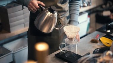 Romanya 'nın Brasov kentindeki bir kafede kahve yapan bir barista. Çaydanlıktan şişeye su dök. Yavaş çekim