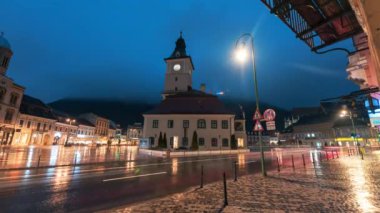 Romanya 'nın Brasov kentindeki Konsey Meydanı' nın gece manzarası. Eski şehir merkezi, klasik binalar, yürüyen insanlar, arabalar, gece lambaları.