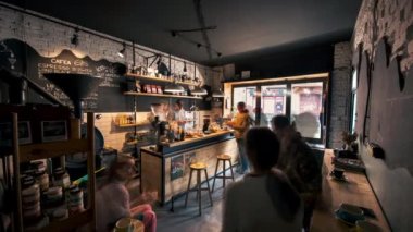 BRASOV, ROMANIA - Nisan 2022: Bir kafenin iç mekanının zamanlaması. Çalışan ve dinlenen insanlar