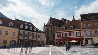BRASOV, ROMANIA - Nisan 2022: Konsey Meydanı 'nın Zaman Çizelgesi. Eski şehir merkezi, Siyah Kilise, klasik binalar, yürüyen insanlar.