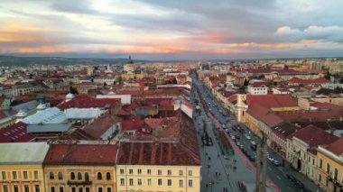 Günbatımında Cluj merkezinin hava aracı görüntüsü, Romanya. Şehir manzarası, yürüyen insanlar, arabalı yollar, eski binalar.