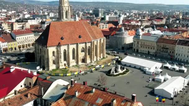 Cluj Napoca Romania エイプリル2022 ルーマニアのクルジュにあるサンマイケル教会の空中ドローンビュー 都市景観 人々と中央広場 古い建物 — ストック動画