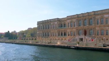 Dolmabahce Sarayı 'nın yüzen bir tekneden görünüşü. İstanbul, Türkiye 'de bahçe ve önünde insanlar