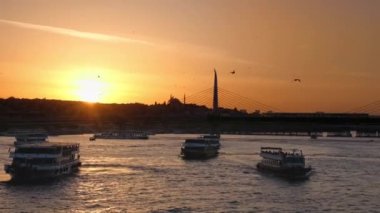 Günbatımında İstanbul şehri manzarası, Türkiye. Boğaz 'da kayıklar, baraj sokakları, sıra sıra konut binaları, camiler var.