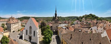 Romanya 'nın Sighisoara Tarih Merkezi' nin panoramik hava aracı görüntüsü. Eski binalar, insanlarla dolu dar sokaklar, Sighisoara Saat Kulesi