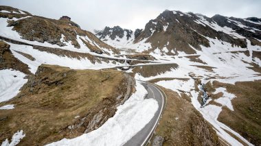 Romanya 'da doğanın insansız hava aracı görüntüsü. Karpat dağlarında arabalı transfagarasan rotası, vadide karla kaplı dağlar.