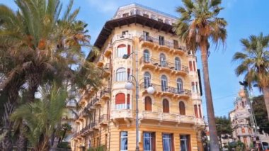 SANREMO, İTALYA - MAYIS 2022: Önünde otomobiller ve yeşillikler olan klasik stil, yol yapımı konut binası