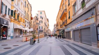 SANREMO, İtalya - Mayıs 2022: şehrin sokak manzarası. Yürüyen insanlar, dükkanlar, klasik binalar...