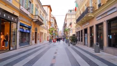 SANREMO, İtalya - Mayıs 2022: şehrin sokak manzarası. Yürüyen insanlar, dükkanlar, klasik binalar...