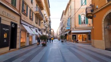 SANREMO, İtalya - Mayıs 2022: şehrin sokak manzarası. Yürüyen insanlar, dükkanlar, klasik binalar...