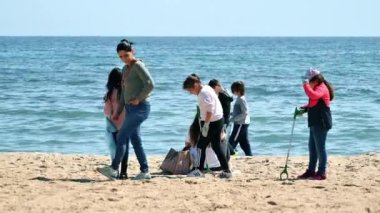 CANNES, FRANCE - Mayıs 2022: Bir grup çocuk ve bir yetişkin Akdeniz kıyısında yürüyüp çöp topluyorlar