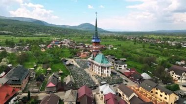 Romanya 'nın Sapanta kentindeki Merry Mezarlığı' nın insansız hava aracı görüntüsü. Kilise ve mezarlık, etrafındaki yerleşim yerleri.