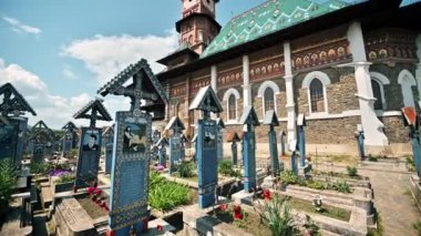 SAPANTA, ROMANIA - Mayıs 2022: Merry Mezarlığı 'ndaki mezar taşları ve ana kilise manzarası