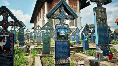 SAPANTA, ROMANIA - Mayıs 2022: Merry Mezarlığı 'ndaki mezar taşları ve ana kilise manzarası