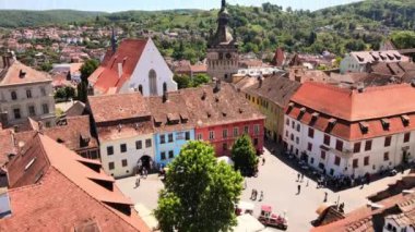 SIGHISOARA, ROMANIA - MAYIS 2022: Romanya 'nın Sighisoara Tarihi Merkezi' nin insansız hava aracı görüntüsü. Eski binalar, insanlarla dolu meydan, Sighisoara Saat Kulesi