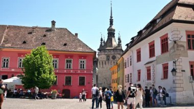SIGHISOARA, ROMANIA - Mayıs 2022: Kasaba Tarihi Merkezi manzarası. Birden fazla insan, Saat Kulesi, eski binalar
