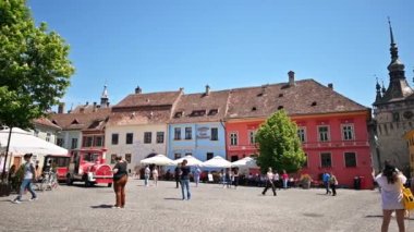 SIGHISOARA, ROMANIA - Mayıs 2022: Kasaba Tarihi Merkezi manzarası. Birden fazla insan, Saat Kulesi, eski binalar