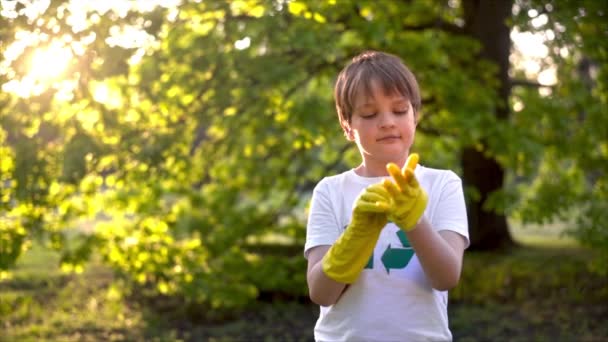 Pojke Sätta Gummihandskar För Plast Sophämtning Förorenad Park Återvinning Tecken — Stockvideo