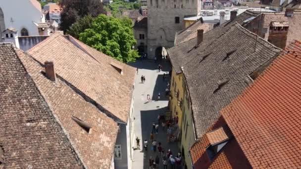 シギソアラ ルーマニア 2022年5月 町の歴史的中心部の空中ドローンビュー 古い建物 人々と狭い通り 西磯良時計塔 — ストック動画