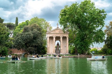 ROMA, İTALYA - 2022 Villa Borghese Bahçeleri içinde yüzen insanlar, yeşillik ve antik Roma binası