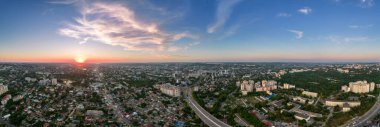 Chisinau 'nun günbatımında hava aracı panoramik görüntüsü. Yollar, yeşillik, birden fazla bina. Moldova