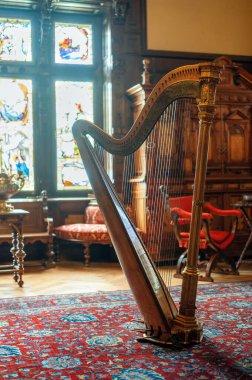 Peles Castle interior in Romania. Room with a harp