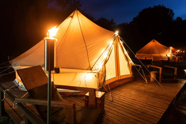 Tents Burning Torches Lamps Wooden Chairs Glamping Forest Night — Stok fotoğraf
