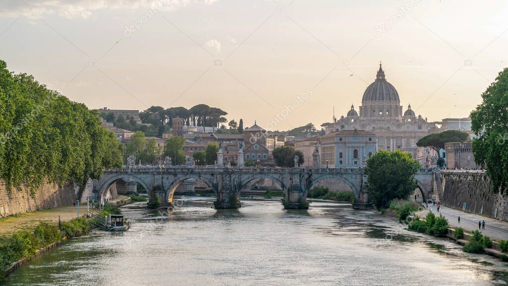 View of the Tiber River in the center of Rome, Italy. Embankment street, multiple buildings and Saint Peter Basilica in the distance
