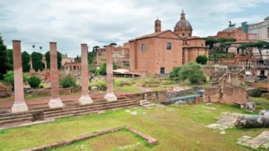 View of the Roman Forum in Rome, Italy. Ancient excavations with old buildings on the background, walking people