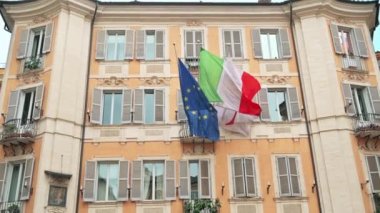 Roma, İtalya 'da üzerinde bayraklar olan klasik tarzda yapılmış bir konut binasının cephesi