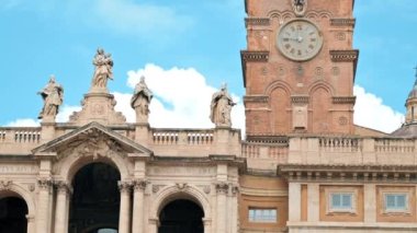ROME, ITALY - JUNE, 2022: An old building made in classic style with sculptures and painted facade, tower on the background