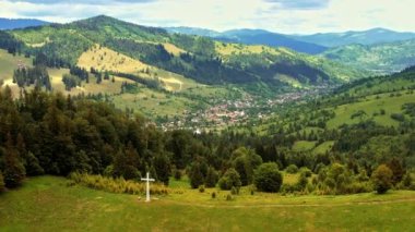 Günbatımında Romanya 'daki Karpatlar' da doğanın insansız hava aracı görüntüsü. Vadideki köy, yemyeşil ormanlarla kaplı tepeler.
