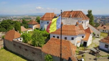 Aerial drone view of The Citadel in Brasov, Romania. Medieval fortress on the top of a hill. Buildings, green trees
