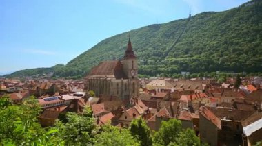 Romanya 'nın eski Brasov merkez manzarası. Siyah Kilise, eski apartmanlar, arka planda yeşil tepe.
