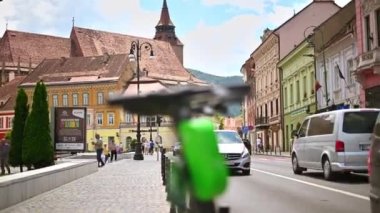 BRASOV, ROMANIA - HAZİRAN 2022: Hareket halindeki arabalarla sokakta paylaşmak için Lime elektrikli scooter sıraları