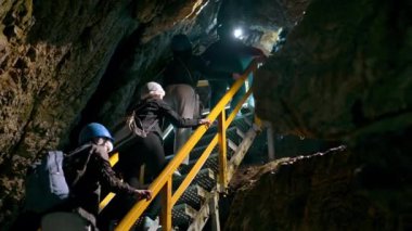 BUCEGI, ROMANIA - Haziran 2022: Bucegi Dağlarındaki Ialomitei Mağarası. Yürüyen turistler, merdivenler, aydınlatma