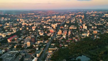Chisinau 'nun günbatımında hava aracı görüntüsü. Birden fazla binanın manzarası, yollar, yemyeşil alanlar. Moldova